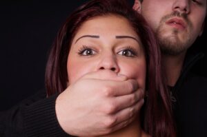 stranger covering the mouth of a terrified girl